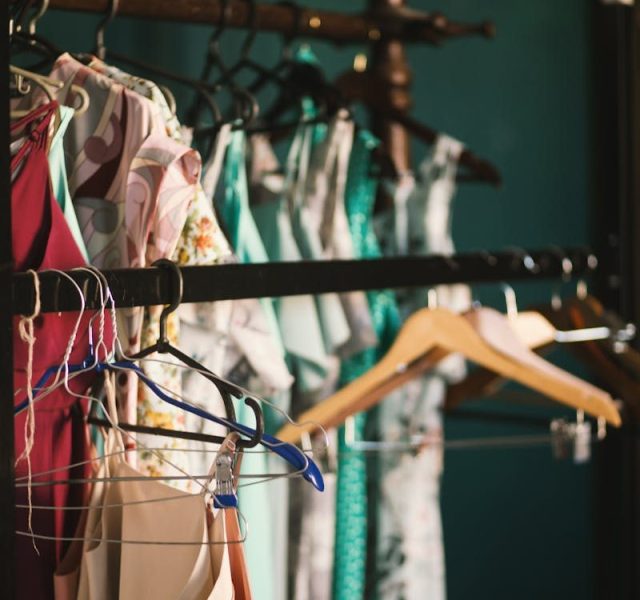 A collection of elegant dresses hanging on a clothes rack in a stylish wardrobe setup.